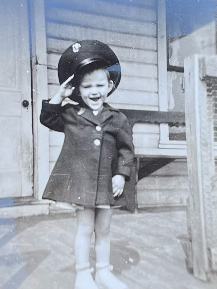 A photo of Mary as a toddler, giving a salute