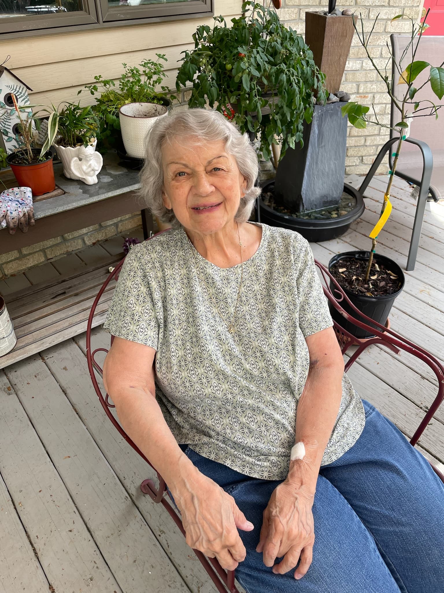 Mary smiling, sitting on outside on her daughter's deck